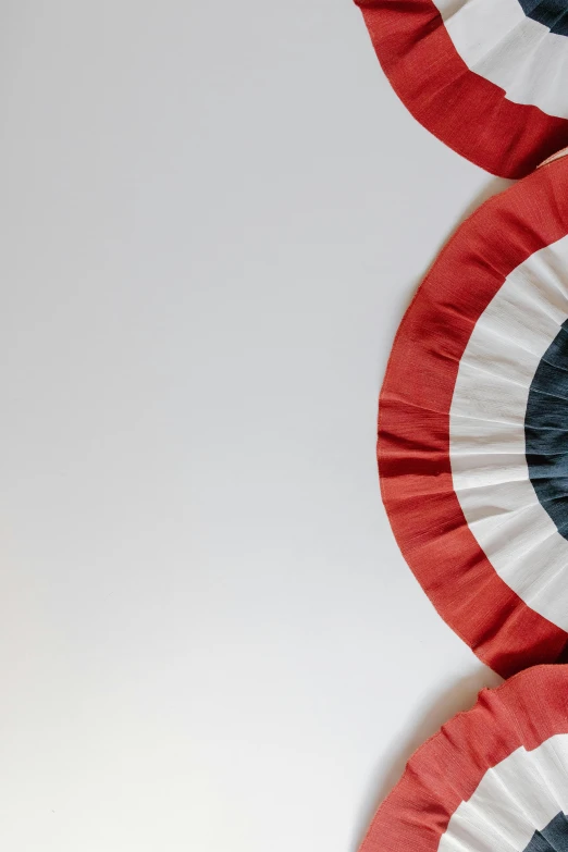 a group of red, white and blue paper fans, an album cover, by Doug Ohlson, trending on unsplash, superhero cape, round-cropped, looking from slightly below, shield