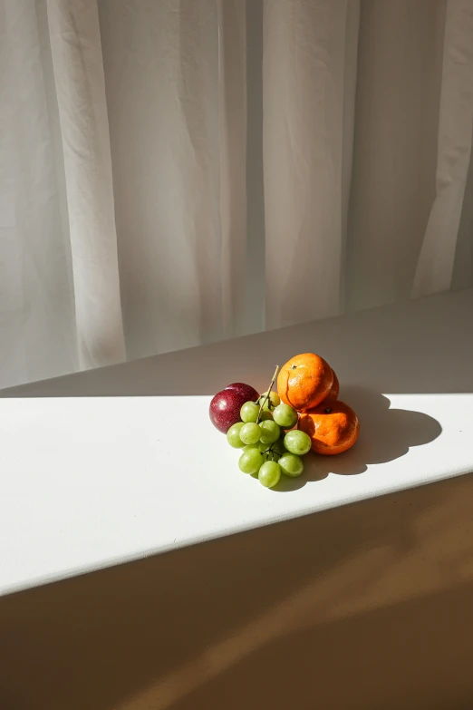 a close up of a plate of fruit on a table, a still life, by Nina Hamnett, unsplash, photorealism, soft backlight, translucent grapes, orange and white, window light