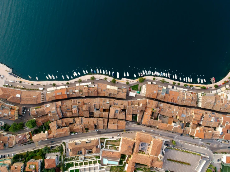 an aerial view of a city next to a body of water, by Bernard D’Andrea, pexels contest winner, photorealism, mediterranean fisher village, precise lines, photogrammetry, roofs