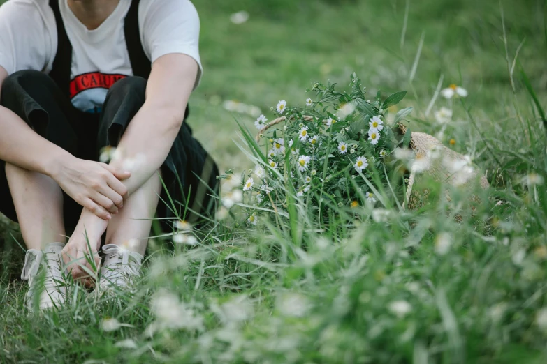 a woman sitting on top of a lush green field, holding paws, chamomile, letterboxing, human back legs and sneakers