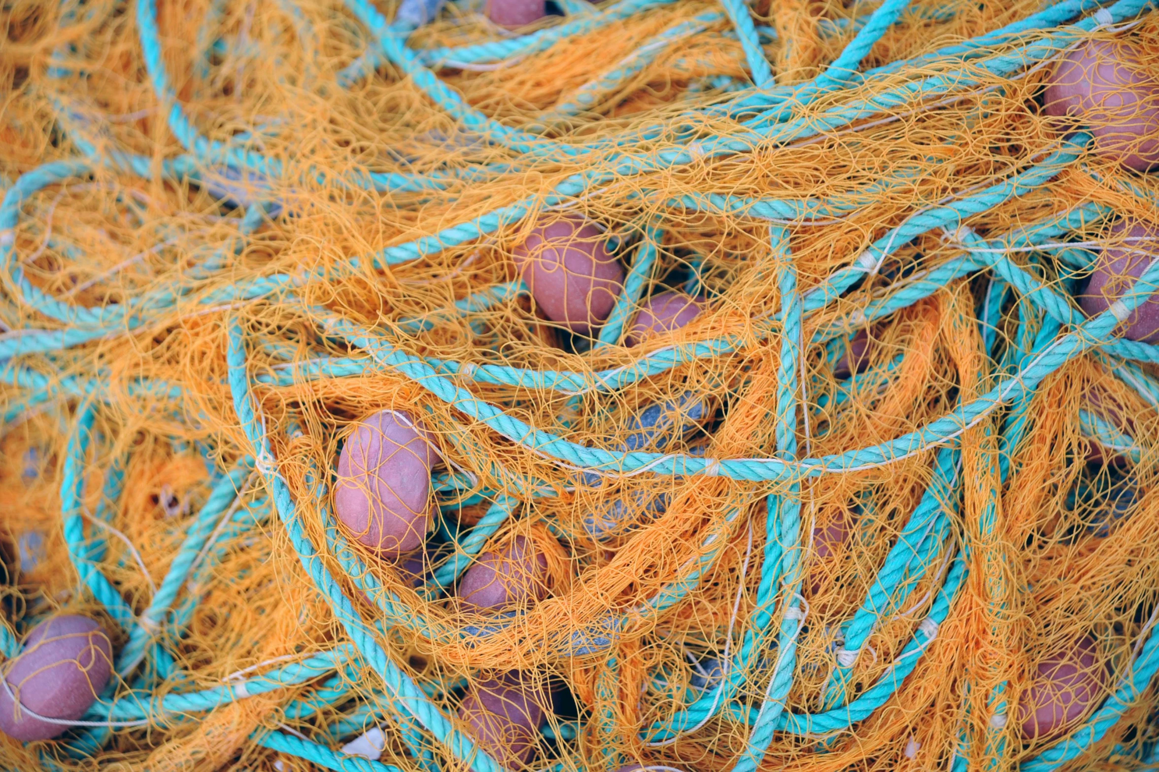 a pile of blue and orange fishing nets, potato, up close, shot on hasselblad, stockphoto