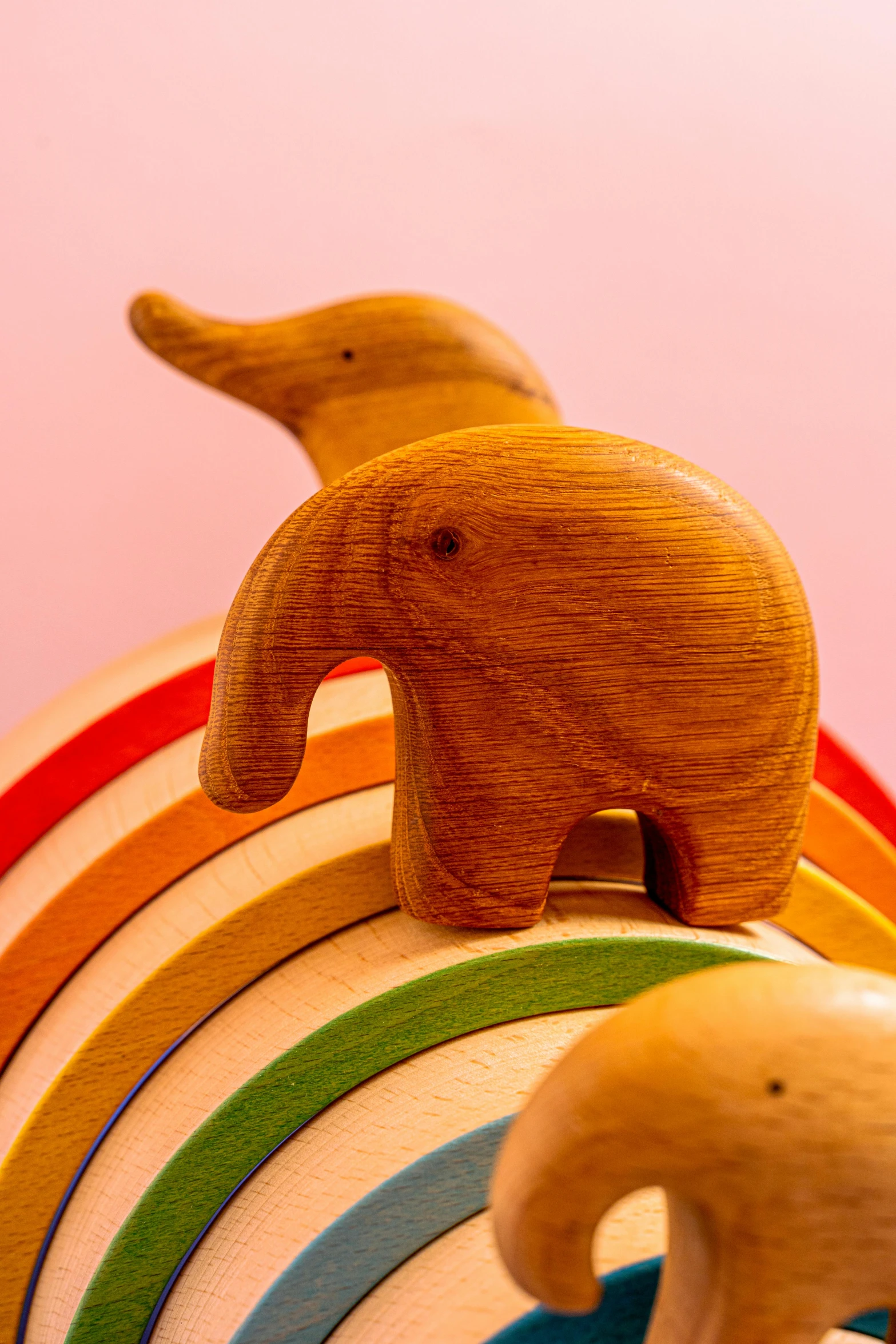 a toy elephant standing on top of a stack of wooden toys, inspired by Okuda Gensō, trending on unsplash, pink and orange colors, wooden bowl, detail shot, detailed product image