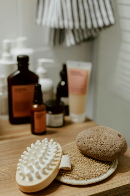 a couple of soaps sitting on top of a wooden counter, a picture, by Elizabeth Durack, unsplash, dry brushing, in bathroom, various items, bumps