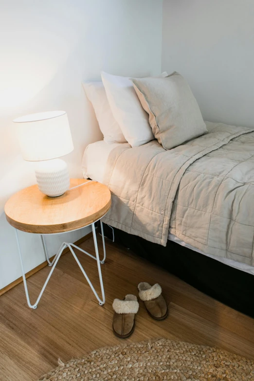 a bed room with a neatly made bed and a night stand, inspired by Isamu Noguchi, trending on unsplash, natural wood top, cream and white color scheme, detail shot, multiple stories