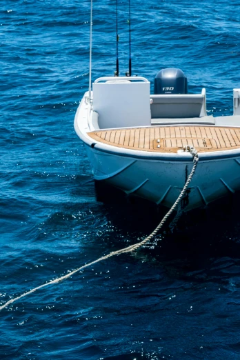 a white boat floating on top of a body of water, ropes, deep blue water, up close, slide show