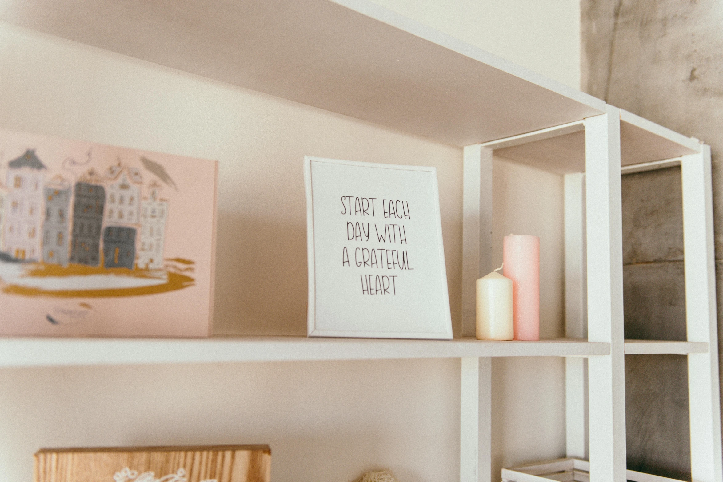 a shelf that has some pictures on it, a picture, by Julia Pishtar, pexels contest winner, private press, inspirational quote, white and pink, bright daylight indoor photo, built on a small