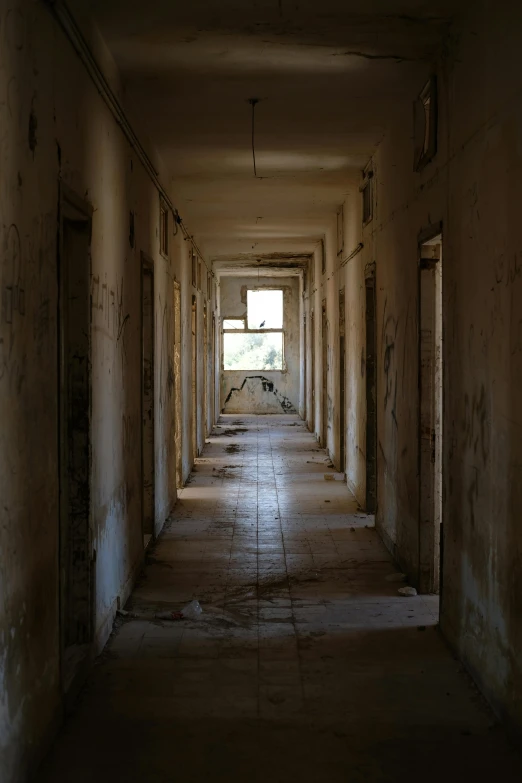 a long hallway leading to a window in a building, by Anna Haifisch, citadel of erbil, “derelict architecture buildings, military base, mess