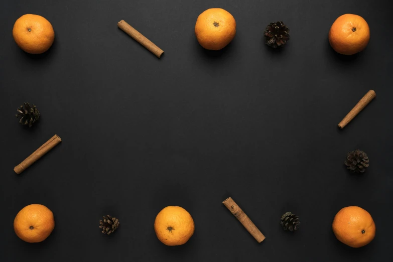 oranges and cinnamon sticks arranged in a circle on a black background, pexels contest winner, minimalism, background image, candy decorations, bells