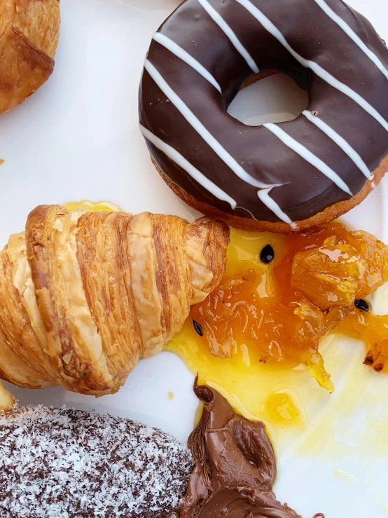 a white plate topped with different types of doughnuts, a still life, by Robbie Trevino, close - up photo, chocolate, thumbnail, cornucopia