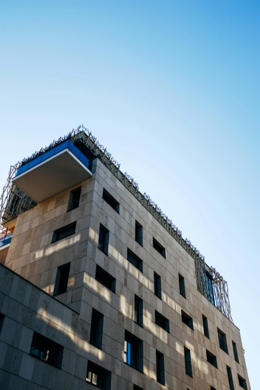 a very tall building with a lot of windows, unsplash, modernism, tehran, under construction, concrete balcony, low - angle shot from behind