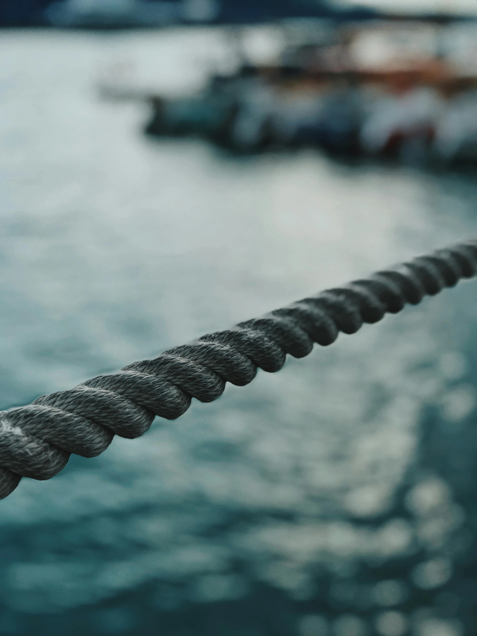 a close up of a rope near a body of water, sitting down, upclose