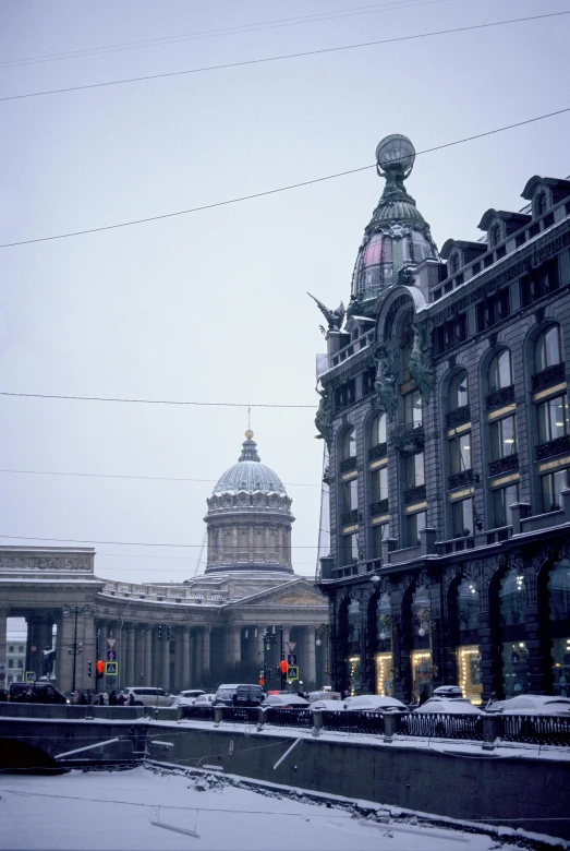 a large building with a clock on top of it, inspired by Illarion Pryanishnikov, renaissance, street elevation, in winter, 1990s photograph, trams