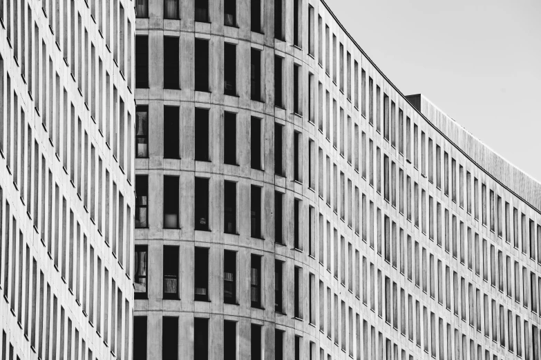 a black and white photo of a tall building, inspired by David Chipperfield, pexels contest winner, rounded corners, berlin city, golden windows, bauhause