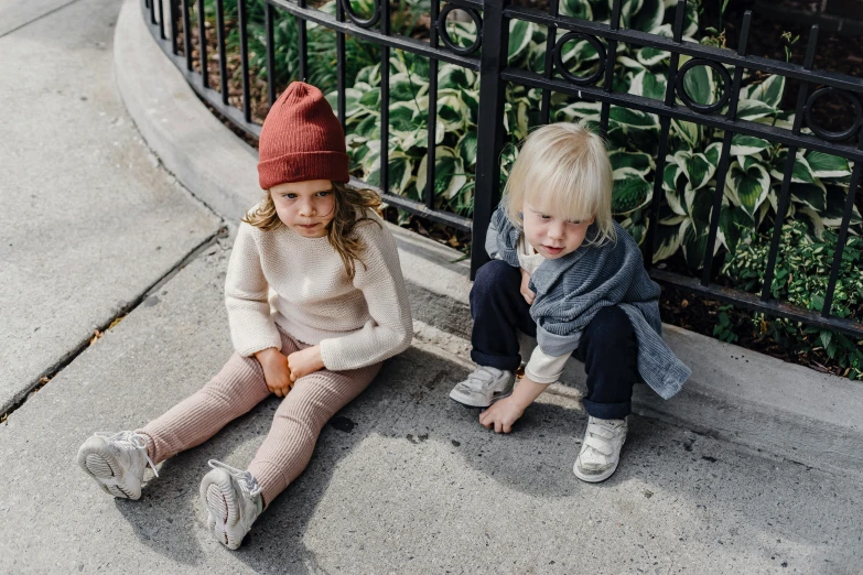 two children sitting next to each other on a sidewalk, by Nina Hamnett, pexels contest winner, beanie, payne's grey and venetian red, bowater charlie and brom gerald, carefully crafted