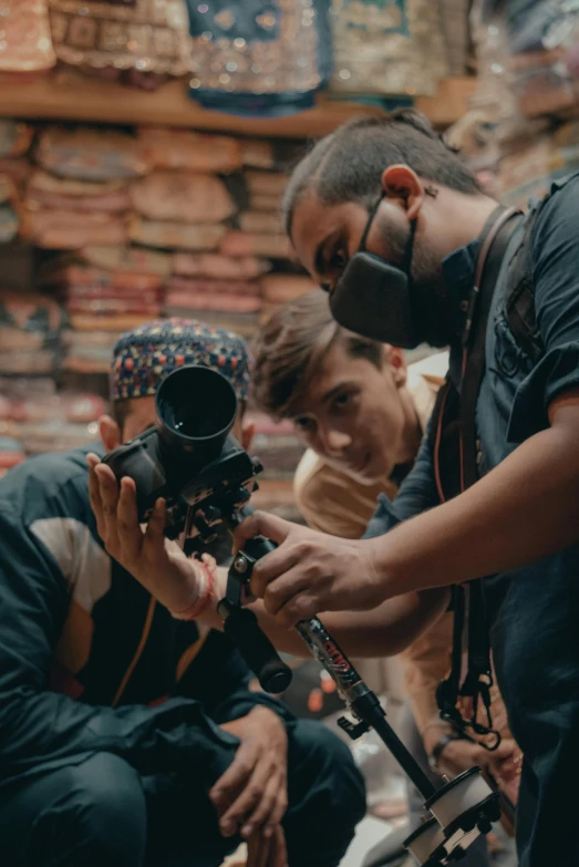 a group of men standing around a camera, masking, highly focused, merchants, asher duran