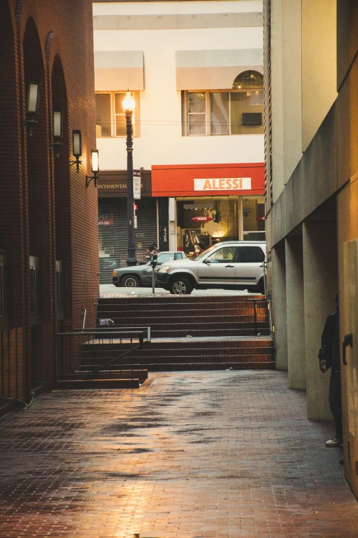 a red fire hydrant sitting on the side of a building, inspired by Elsa Bleda, unsplash, photograph of the city street, penrose stairs, cars and people, narrow passage