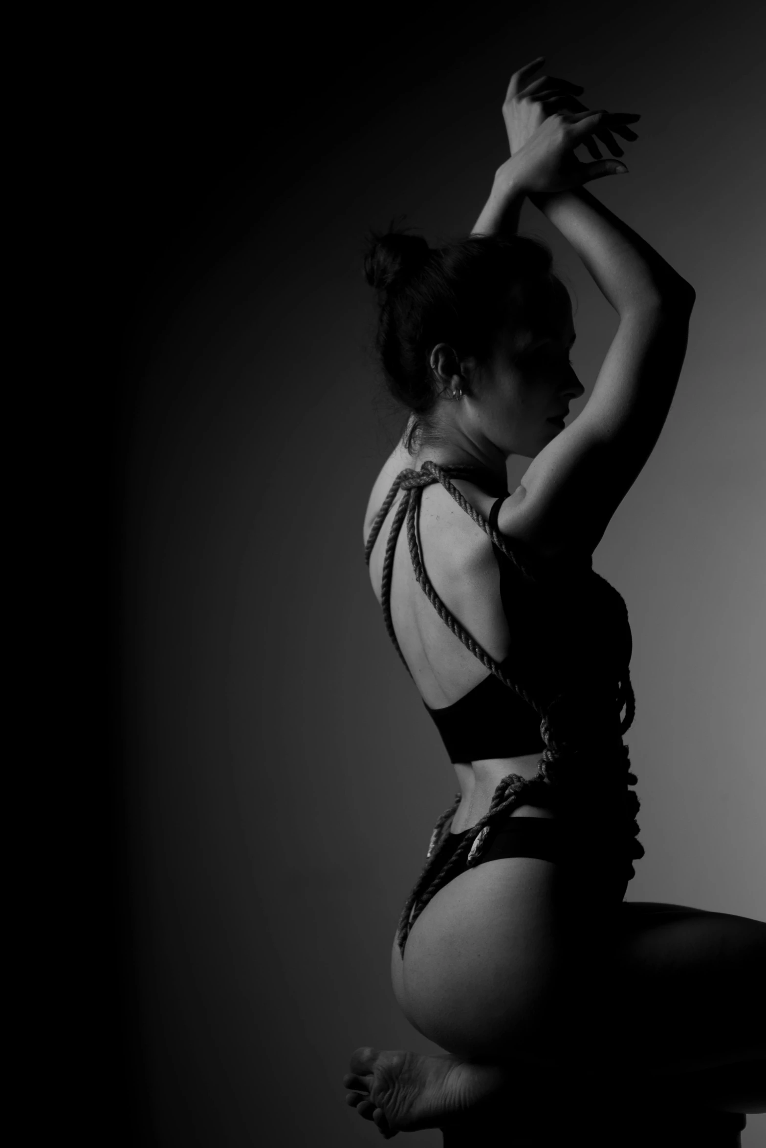 a black and white photo of a woman in a leo leo leo leo leo leo leo leo leo leo leo leo leo leo leo, inspired by Roberto Ferri, flickr, body harness, thoughtful pose, back lit, charli xcx