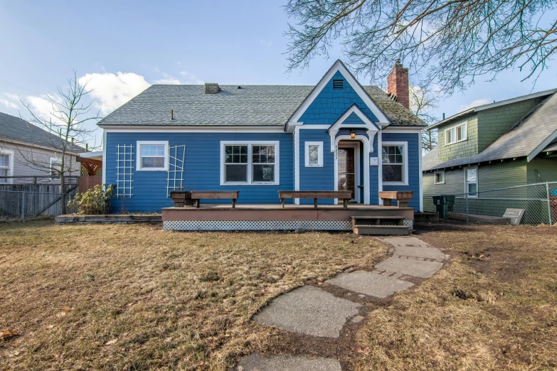 a blue house sitting on top of a grass covered field, by Carey Morris, portland oregon, listing image, with a front porch, brown