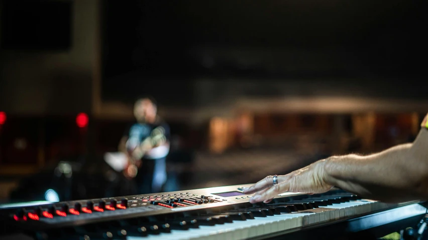 a close up of a person playing a musical instrument, by Dan Content, cinematic image, keyboardist, person in foreground, theatre equipment