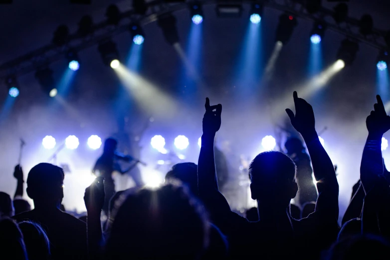 a crowd of people at a concert with their hands in the air, pexels contest winner, dramatic white and blue lighting, playing guitar onstage, trending on imagestation, rabbids at a metal concert