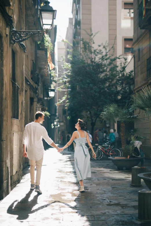 a man and a woman walking down a narrow street, pexels contest winner, barcelona, romantic scene, full sun, lush surroundings