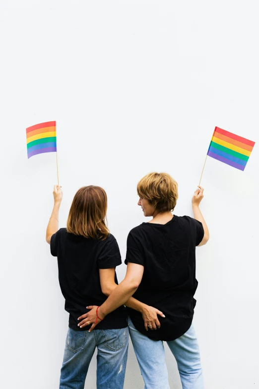 two people holding rainbow flags against a white wall, trending on unsplash, androgynous person, profile image, concert, 🚿🗝📝