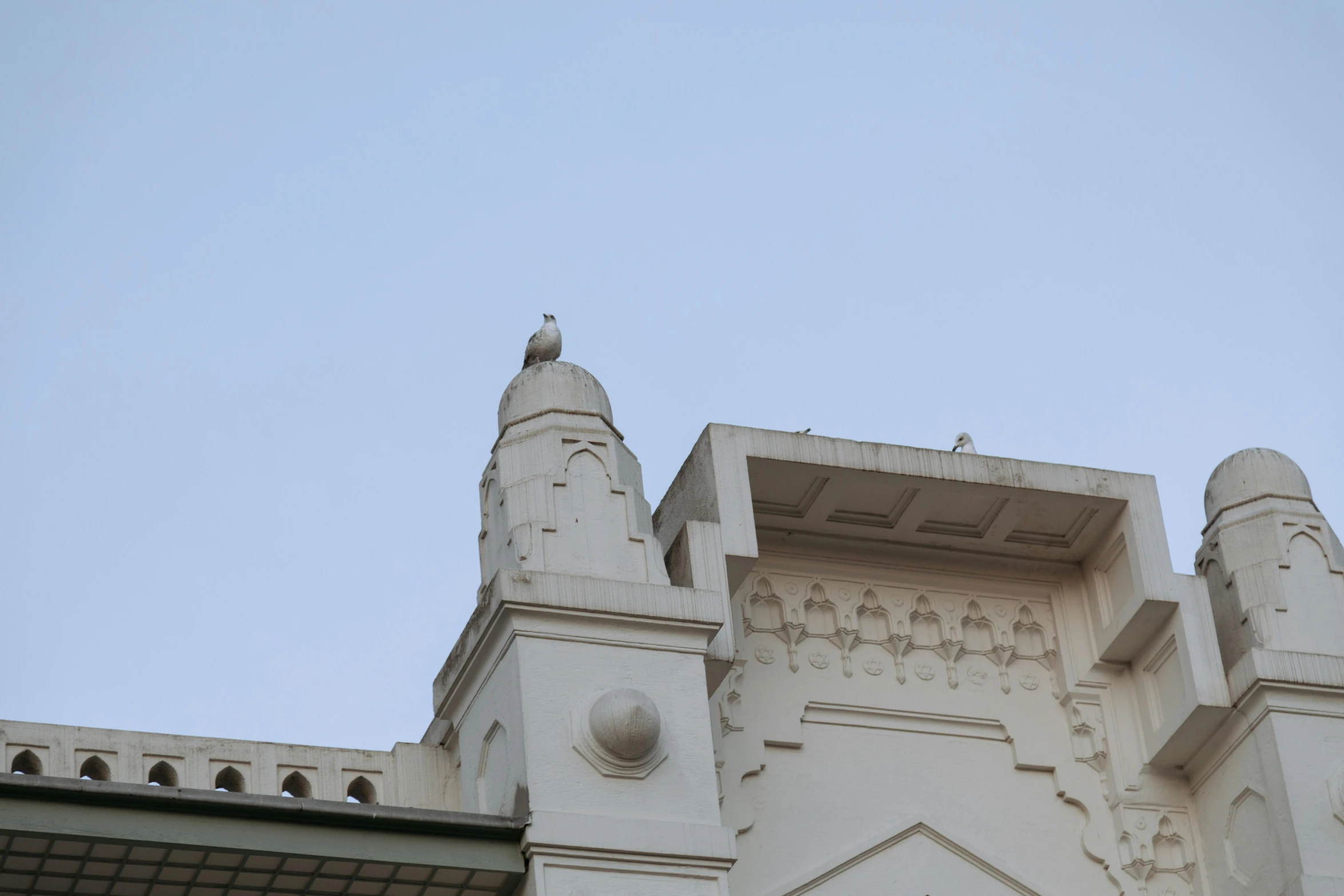 a clock that is on the side of a building, a statue, inspired by Osman Hamdi Bey, unsplash, bengal school of art, carved in white marble, view from bottom to top, chimneys on buildings, high details photo