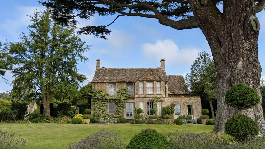 a large house sitting on top of a lush green field, by Simon Marmion, pexels contest winner, arts and crafts movement, john pawson, exterior view, emma bridgewater and paperchase, tourist destination