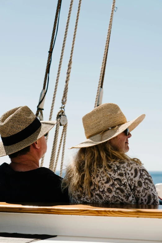 a couple of people that are sitting on a boat, by Gwen Barnard, unsplash, wearing straw hat, sails and masts and rigging, gazing off into the horizon, perfectly shaded