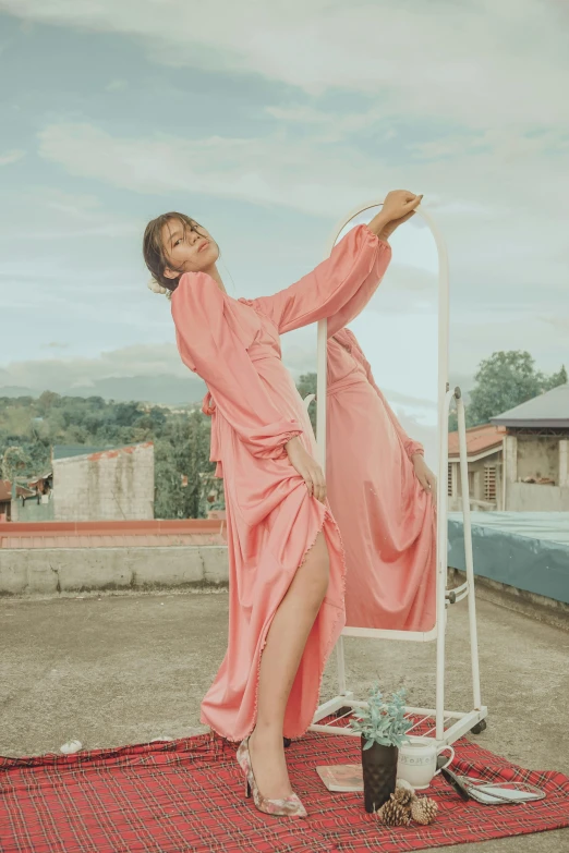 a woman in a pink dress leaning on a ladder, an album cover, inspired by Juan Luna, pexels contest winner, philippines, pose(arms up + happy), fashion editorial, silk robes