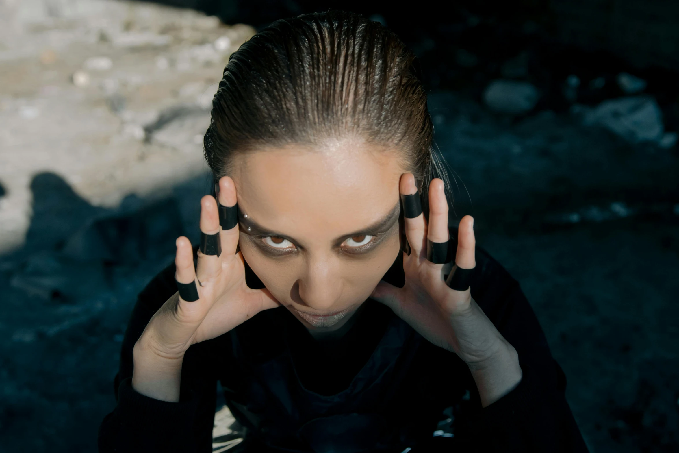 a woman with her hands on her face, an album cover, pexels contest winner, antipodeans, black eye shadow, techwear occultist, still from a music video, artem chebokha