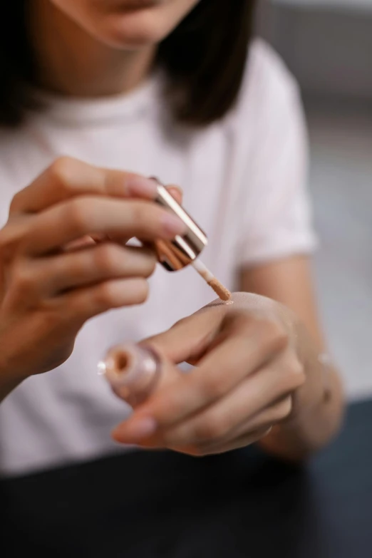 a close up of a person using a nail brush, by Julia Pishtar, copper, teenage girl, skincare, crafts