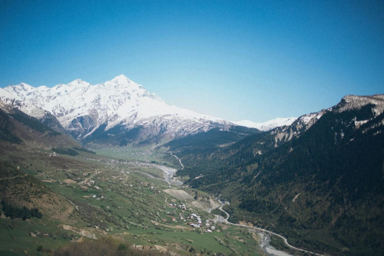 a view of a valley with mountains in the background, an album cover, by Werner Andermatt, pexels contest winner, hurufiyya, f 1.4 kodak portra, caucasian, snowcrash, overview