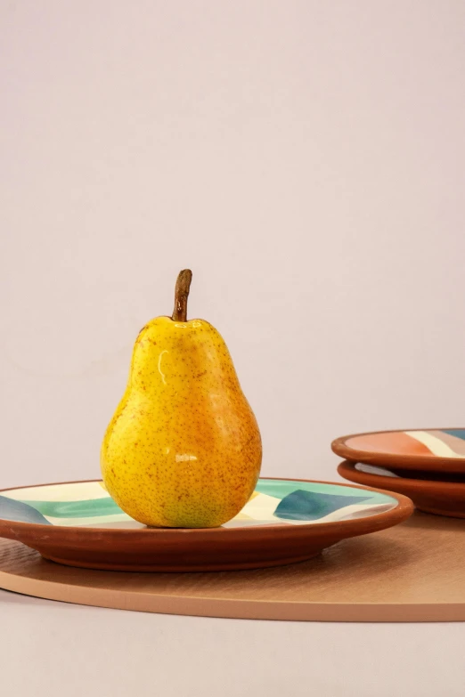 a close up of a plate with a pear on it, colors: yellow, full product shot, patagonian, marterpiece