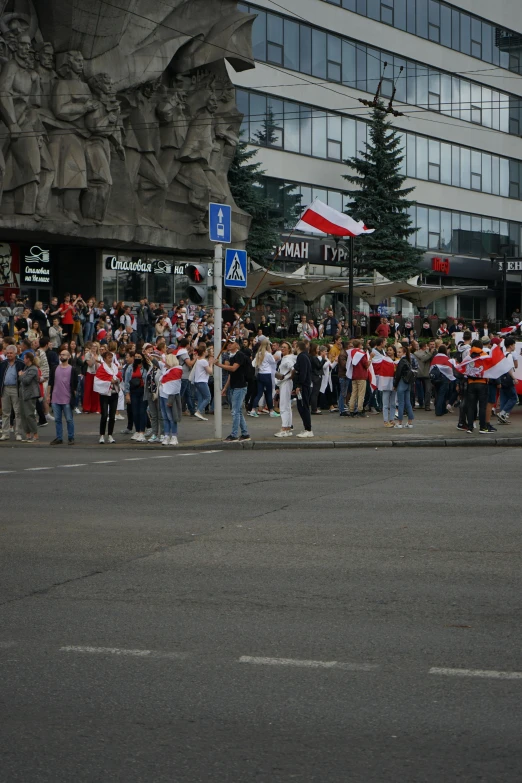 a group of people that are standing in the street, by Attila Meszlenyi, happening, poland flag, low quality photo, square, siberia!!