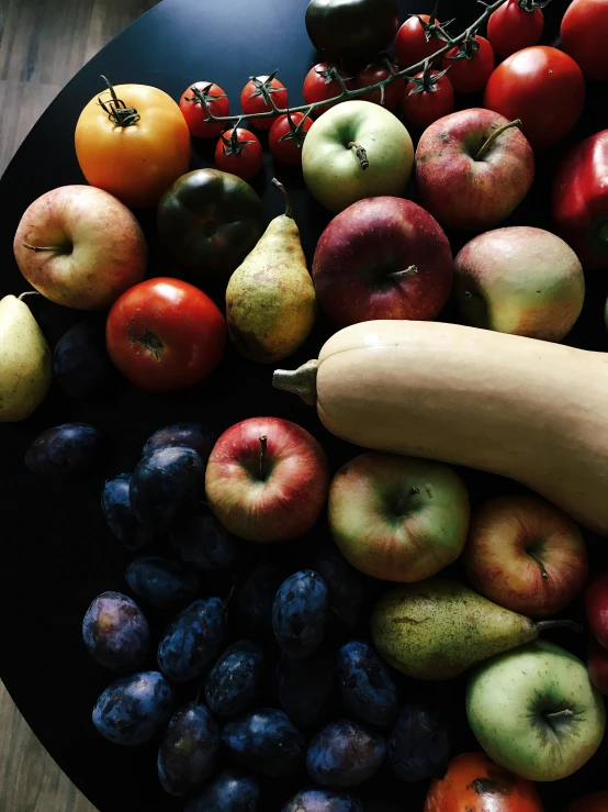 a black plate topped with assorted fruits and vegetables, apples, thumbnail, grainy, last photo