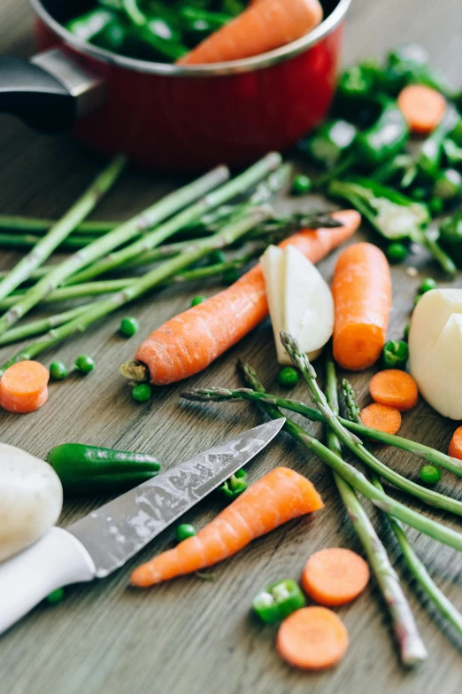 a wooden table topped with carrots and asparagus, unsplash, ingredients on the table, stew, stockphoto, multiple stories