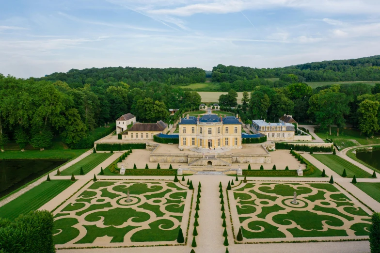 a large building sitting on top of a lush green field, an album cover, inspired by Pierre Mion, pexels contest winner, rococo, wide aerial shot, formal gardens, pur champagne damery, tourist destination