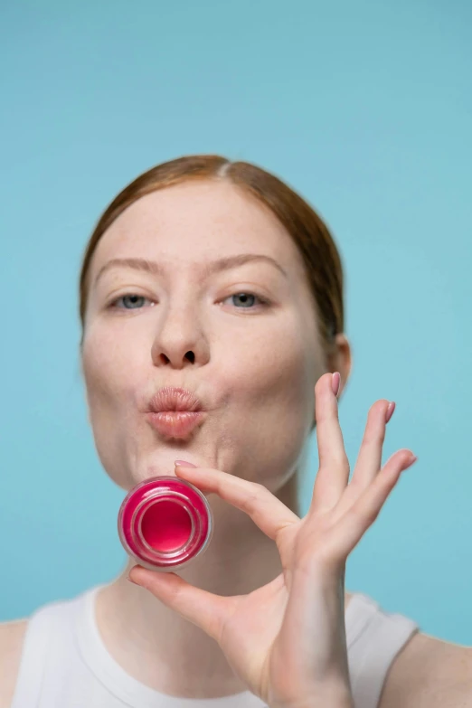 a woman holding a lip bale in front of her face, trending on pexels, pop art, cups and balls, smooth pink skin, holding a tin can, silicone skin