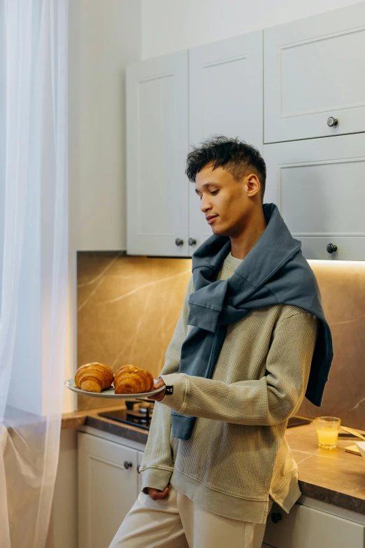 a man standing in a kitchen holding a plate of food, cozy aesthetic, tech robes, profile image, grey