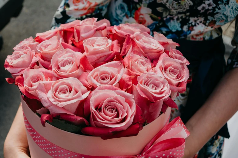a woman holding a box of pink roses, by Maksimilijan Vanka, pixabay, huge flowers, wrapped in flowers, premium quality, 🎀 🍓 🧚