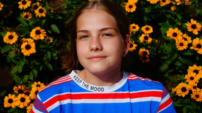 a young girl standing in front of a bunch of flowers, pexels contest winner, wearing a t-shirt, portrait of normal teenage girl, 15081959 21121991 01012000 4k, greta thunberg