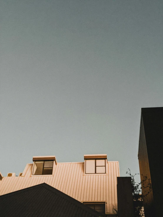 a couple of buildings that are next to each other, a photo, by Carey Morris, trending on unsplash, postminimalism, galvalume metal roofing, late summer evening, trending on vsco, medium format. soft light