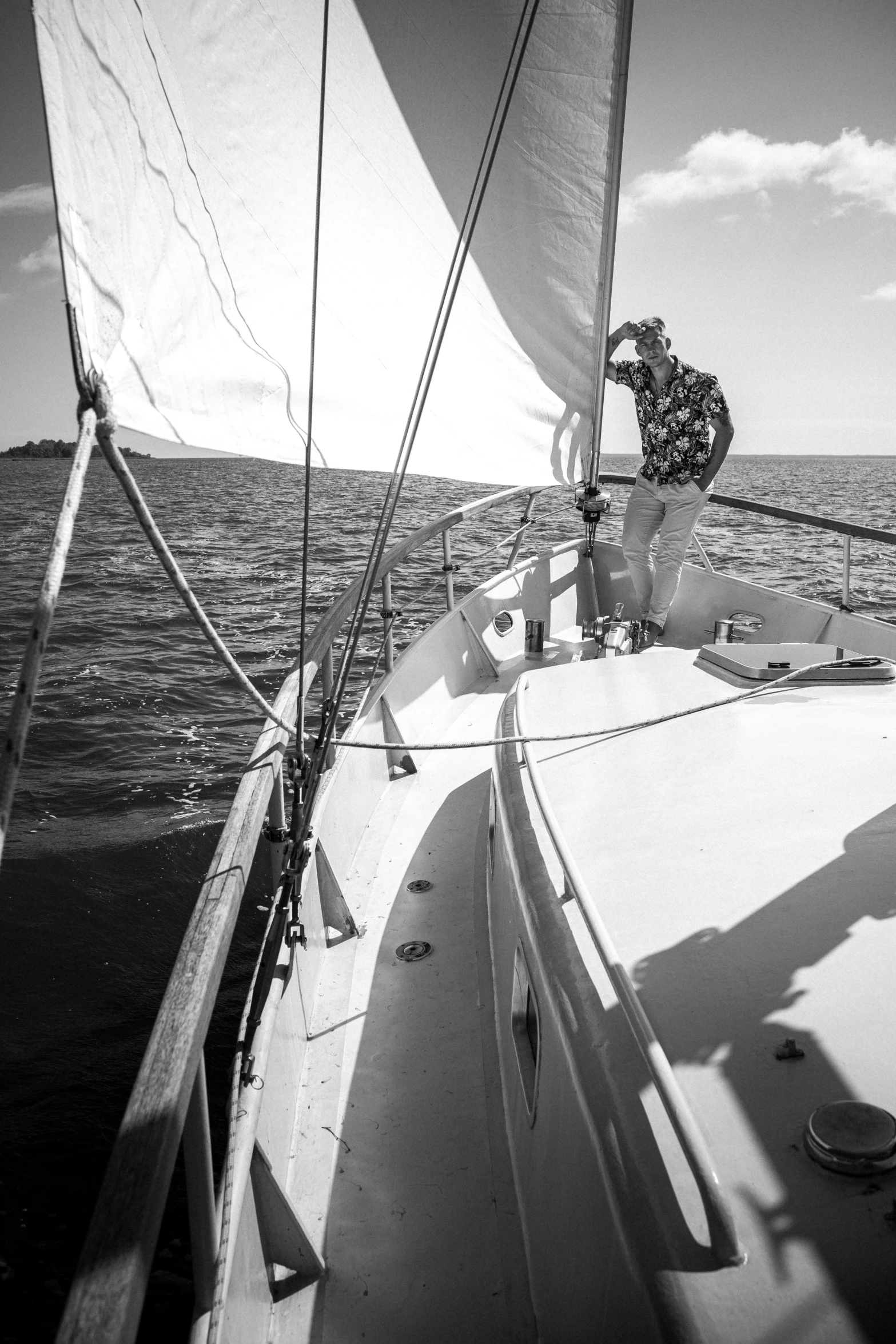 a black and white photo of a man on a sailboat, by Dave Melvin, happening, camaraderie, minn, action photograph, adventuring