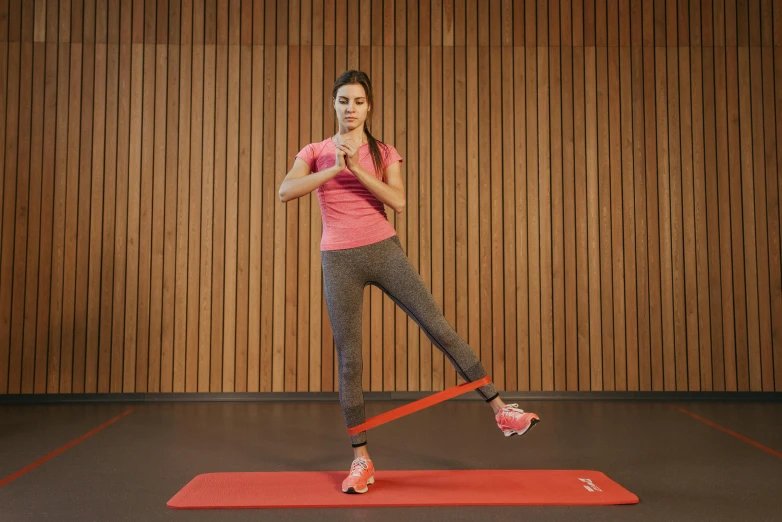 a woman doing an exercise with a resistance band, by david rubín, dribble, coral red, square, technical, full body picture