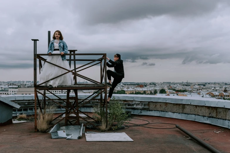 a couple of people standing on top of a building, by Emma Andijewska, happening, sitting on a metal throne, greta thunberg, behind the scenes photo, 15081959 21121991 01012000 4k