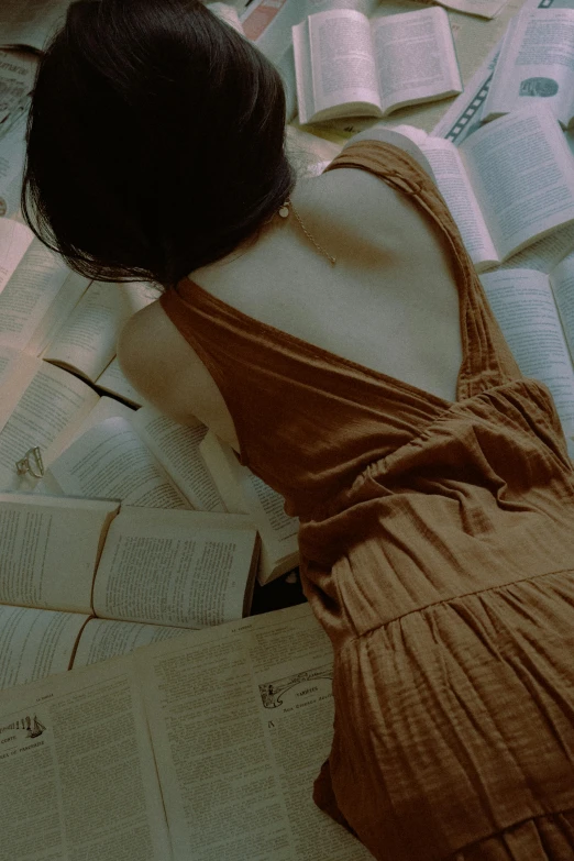 a woman laying on a bed reading a book, by Mei Qing, pexels contest winner, renaissance, open back dress, gif, ulzzang, brown ) )