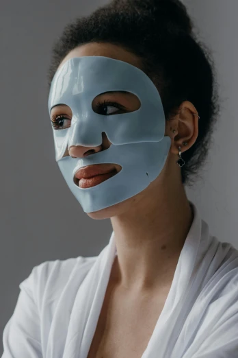 a woman with a blue mask on her face, soft face features, product shot, grey, aesthetics