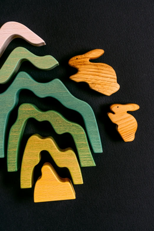 a group of wooden toys sitting on top of a table, inspired by Jean Arp, trending on unsplash, a forest with bunnies, rising from mountain range, detail shot, terraced