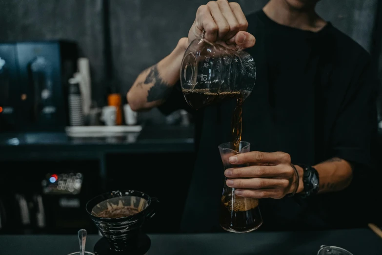 a man pouring a drink into a glass, pexels contest winner, aussie baristas, black and brown colors, thumbnail, resin